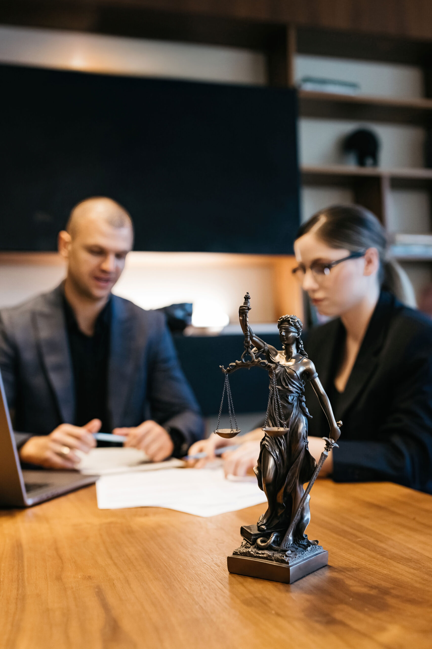 MPU Beratung mit juristischer Unterstützung – Symbolbild mit Justitia-Statue und Fachleuten am Besprechungstisch